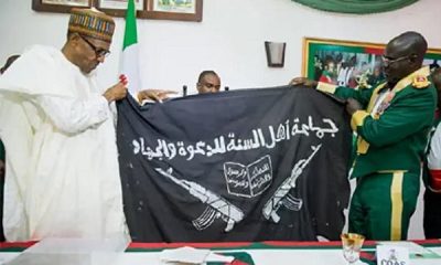 Ex-Chief of Army Staff, Tukur Buratai presenting Boko Haram flag to President Muhammadu Buhari