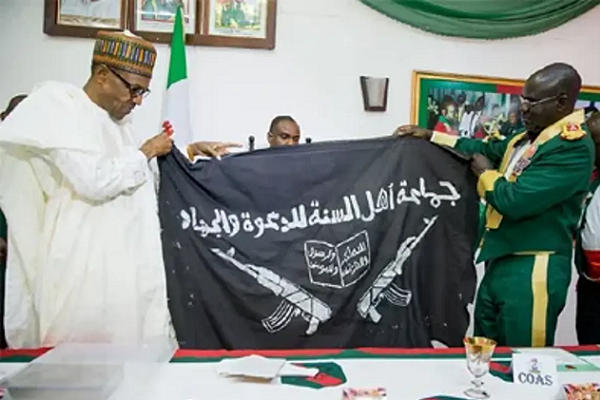 Ex-Chief of Army Staff, Tukur Buratai presenting Boko Haram flag to President Muhammadu Buhari