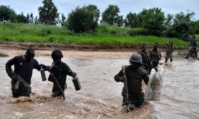 Nigerian Army troops crossing a flooded area