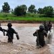 Nigerian Army troops crossing a flooded area