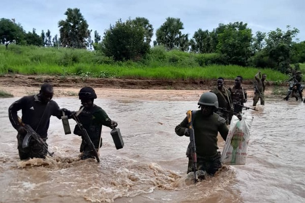 Nigerian Army troops crossing a flooded area