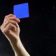 Referee brandishes a Blue Card