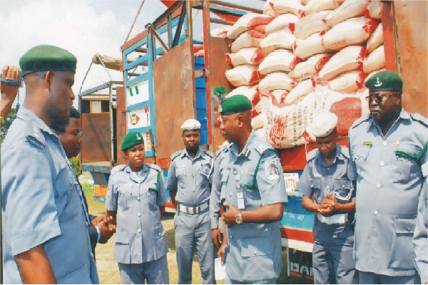 Operatives of the Nigeria Customs Service (NCS) showcase a cache of seized items