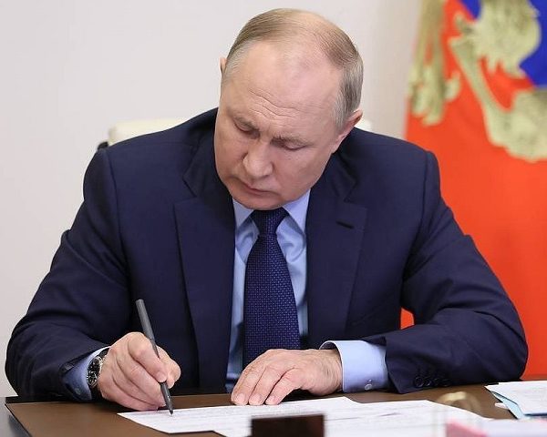 President Vladimir Putin of Russia signing a decree withdrawing Russia from MNEPR
