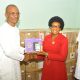 Apostle Nkono (left) presenting a U-Learning tablet to the representative of one of the benefitting schools