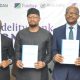 Fidelity Bank and SMEDAN officials display copies of the MoU