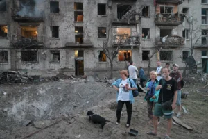 A woman looks at an apartment building burning after a Russian missile attack in Kyiv, Ukraine, Thursday, July 2, 2026. (AP Photo/Danylo Antoniuk)